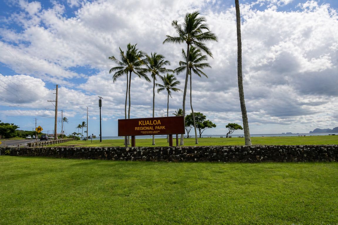 Kualoa Regional Park entrance sign with palm trees and ocean views during a guided tour with our Kualoa Ranch Tours agency